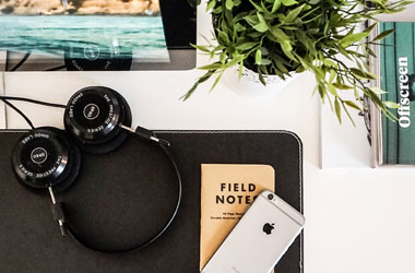 work desk with flowers and headphones
